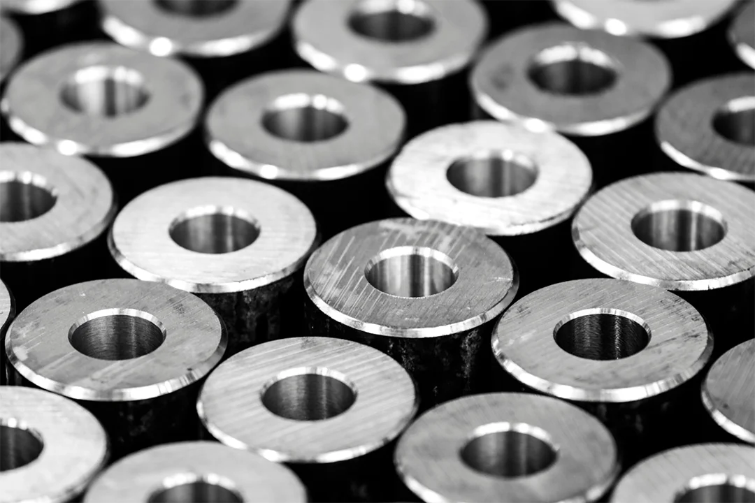 Precision bored shafts are arranged in rows, emphasizing their uniform machining.