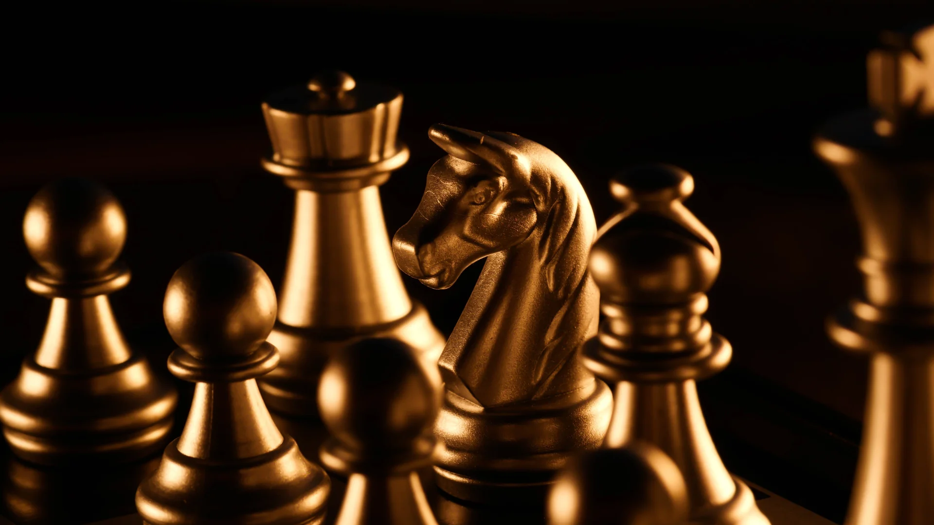 A golden knight chess piece surrounded by other pieces on a chessboard.